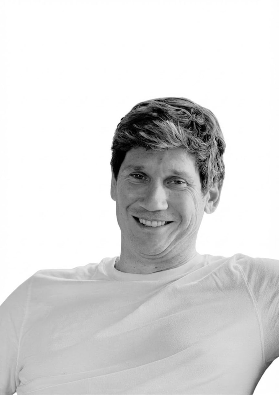 Jack Connor, producer at Vertical Cuts, smiling in a white shirt - black-and-white portrait.